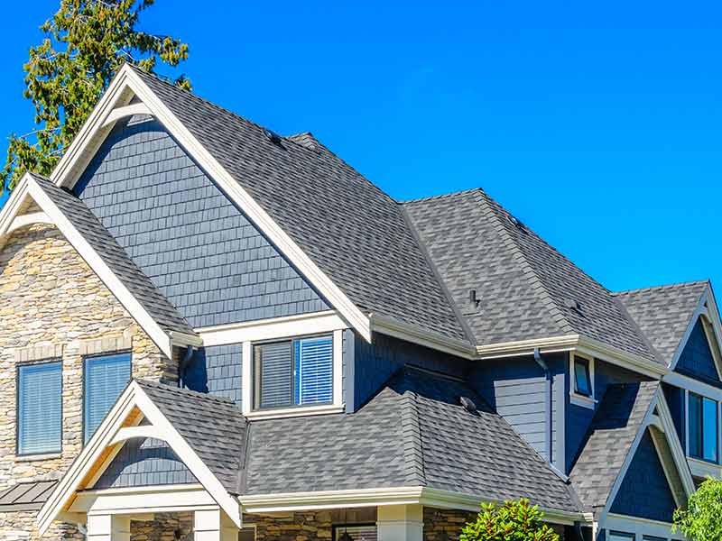 Large, higher-end home with a gray shingle roof